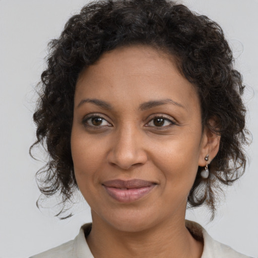 Joyful black young-adult female with medium  brown hair and brown eyes