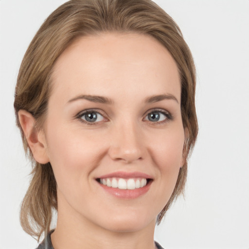 Joyful white young-adult female with medium  brown hair and grey eyes