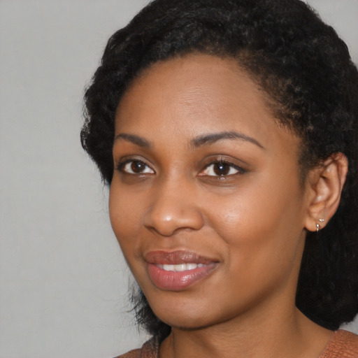 Joyful black young-adult female with medium  black hair and brown eyes