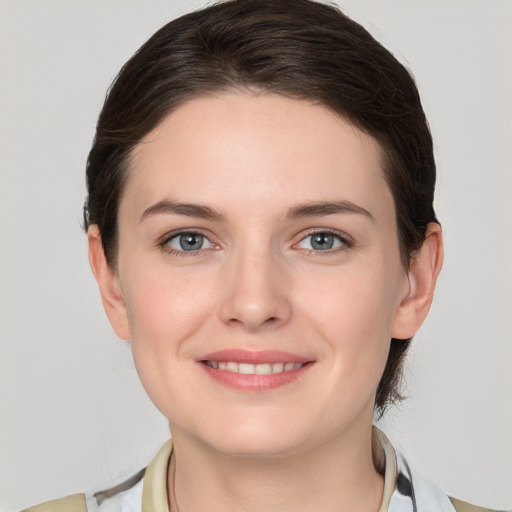 Joyful white young-adult female with medium  brown hair and grey eyes