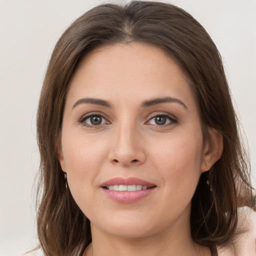 Joyful white young-adult female with long  brown hair and grey eyes