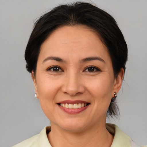 Joyful asian adult female with medium  brown hair and brown eyes