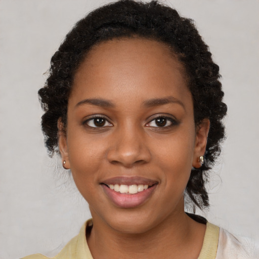 Joyful black young-adult female with short  black hair and brown eyes