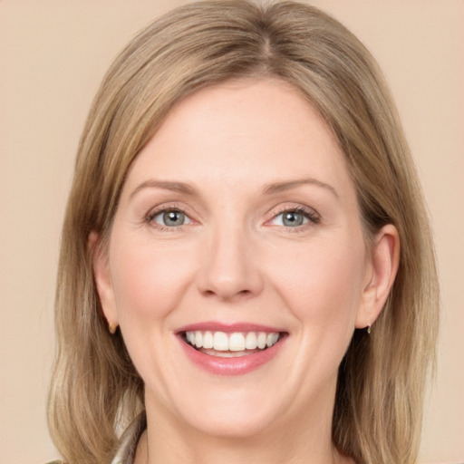 Joyful white adult female with medium  brown hair and green eyes