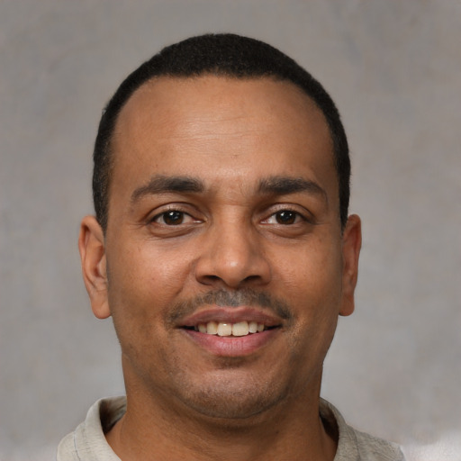 Joyful latino young-adult male with short  brown hair and brown eyes