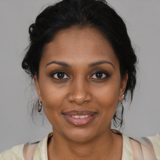 Joyful black adult female with medium  brown hair and brown eyes