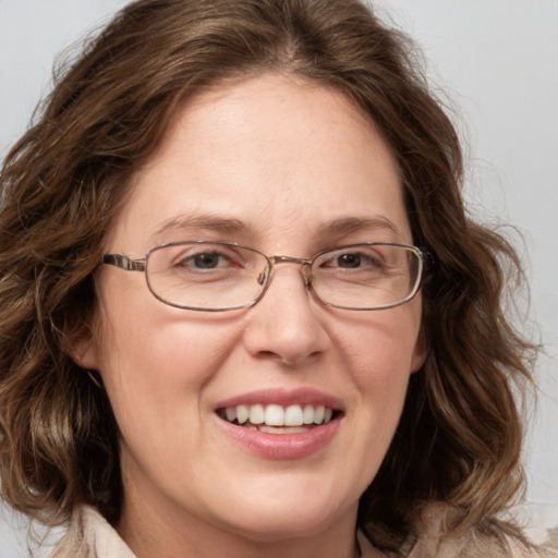 Joyful white adult female with medium  brown hair and blue eyes