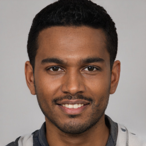 Joyful black young-adult male with short  black hair and brown eyes