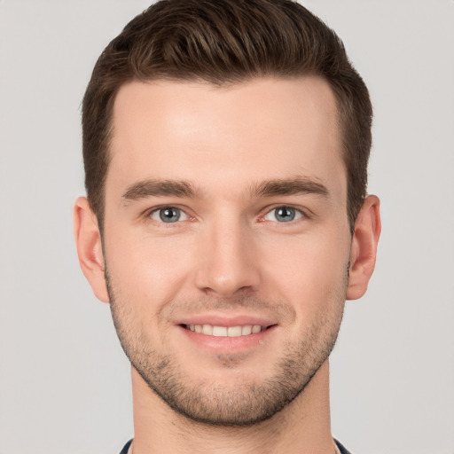 Joyful white young-adult male with short  brown hair and grey eyes