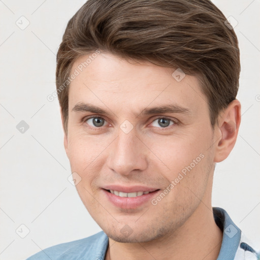 Joyful white young-adult male with short  brown hair and grey eyes