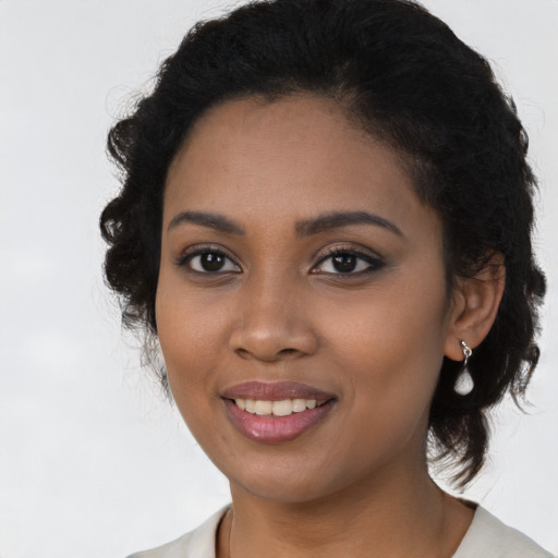 Joyful black young-adult female with medium  black hair and brown eyes