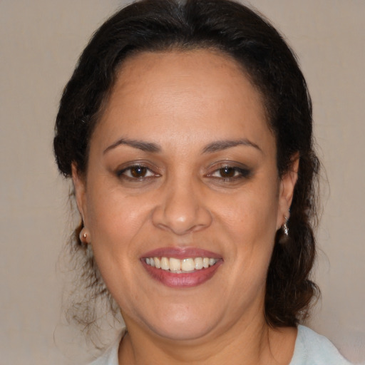 Joyful latino adult female with medium  brown hair and brown eyes