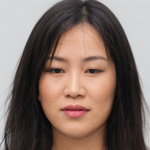 Joyful asian young-adult female with long  brown hair and brown eyes