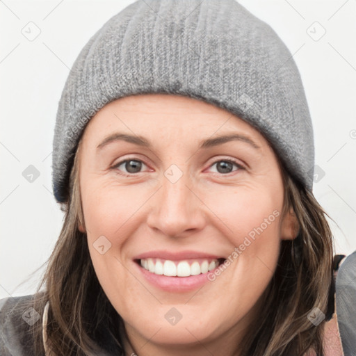 Joyful white young-adult female with medium  brown hair and grey eyes