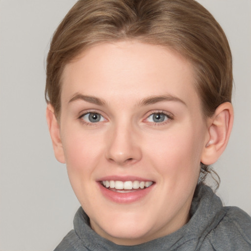 Joyful white young-adult female with short  brown hair and grey eyes