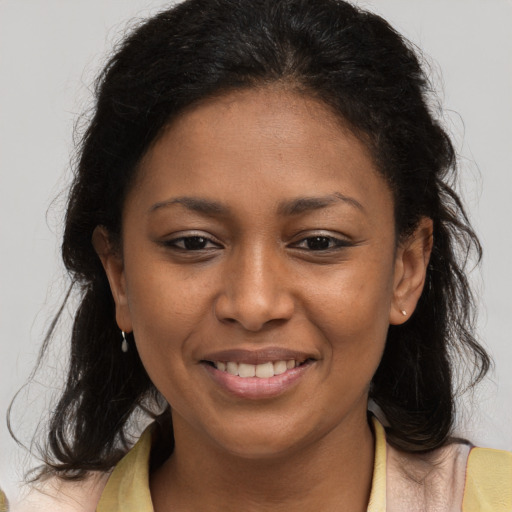 Joyful black young-adult female with long  brown hair and brown eyes