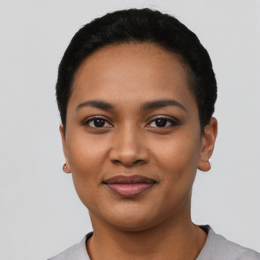 Joyful latino young-adult female with short  black hair and brown eyes