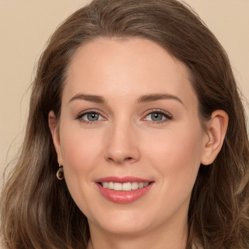 Joyful white young-adult female with long  brown hair and grey eyes