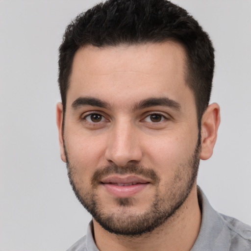 Joyful white young-adult male with short  black hair and brown eyes