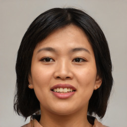 Joyful asian young-adult female with medium  brown hair and brown eyes