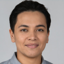 Joyful latino young-adult male with short  black hair and brown eyes