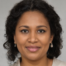 Joyful black adult female with long  brown hair and brown eyes