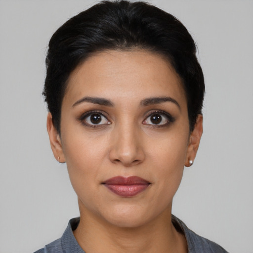Joyful latino young-adult female with short  black hair and brown eyes