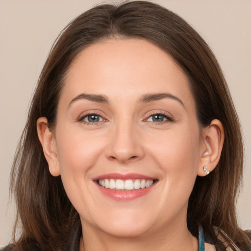 Joyful white young-adult female with long  brown hair and grey eyes