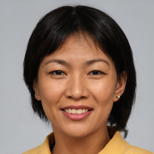 Joyful asian adult female with medium  brown hair and brown eyes