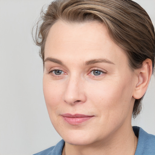 Joyful white adult female with medium  brown hair and blue eyes