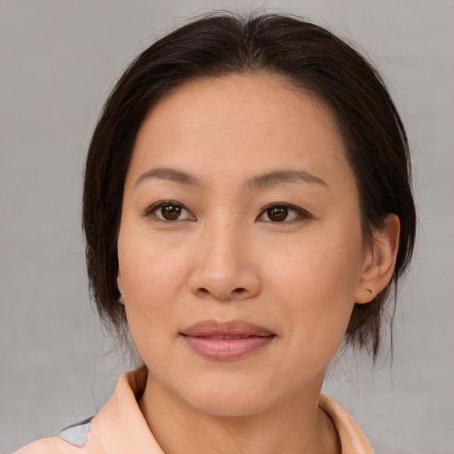 Joyful asian adult female with medium  brown hair and brown eyes