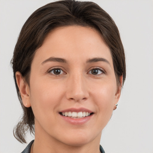 Joyful white young-adult female with medium  brown hair and grey eyes