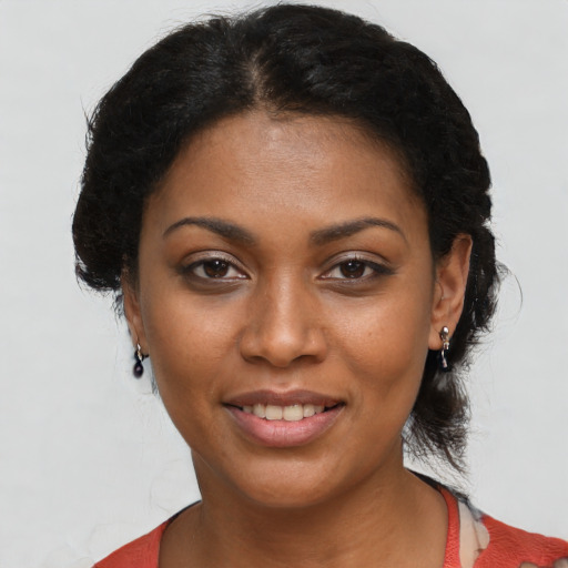 Joyful black young-adult female with short  black hair and brown eyes