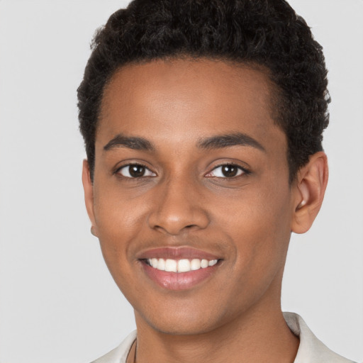 Joyful black young-adult male with short  brown hair and brown eyes