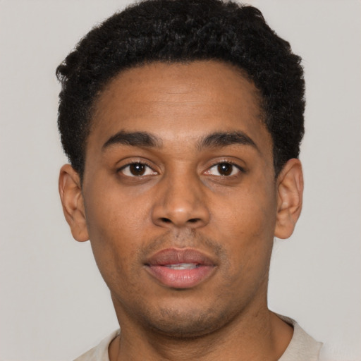 Joyful black young-adult male with short  brown hair and brown eyes