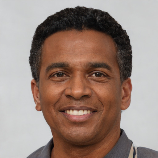 Joyful latino adult male with short  black hair and brown eyes