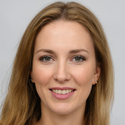 Joyful white young-adult female with long  brown hair and green eyes