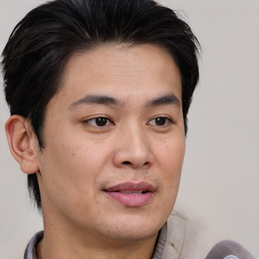 Joyful asian young-adult male with short  brown hair and brown eyes