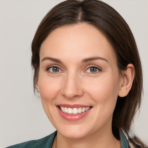 Joyful white young-adult female with medium  brown hair and grey eyes