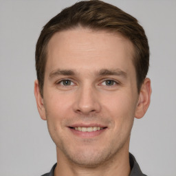 Joyful white young-adult male with short  brown hair and grey eyes