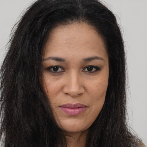 Joyful black young-adult female with long  brown hair and brown eyes