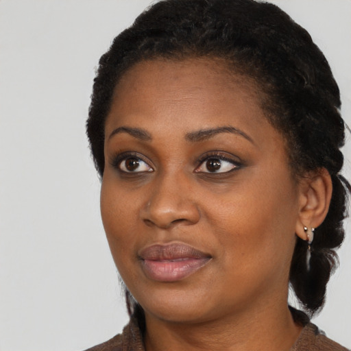 Joyful black young-adult female with long  black hair and brown eyes