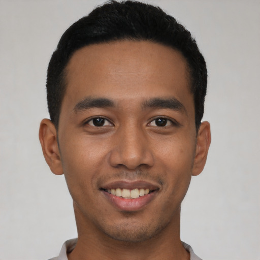 Joyful latino young-adult male with short  black hair and brown eyes