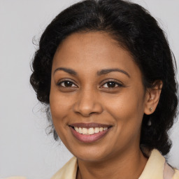 Joyful black young-adult female with long  brown hair and brown eyes