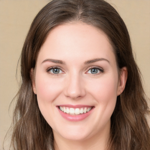 Joyful white young-adult female with long  brown hair and green eyes