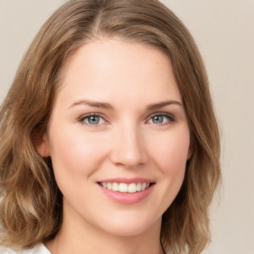 Joyful white young-adult female with medium  brown hair and green eyes