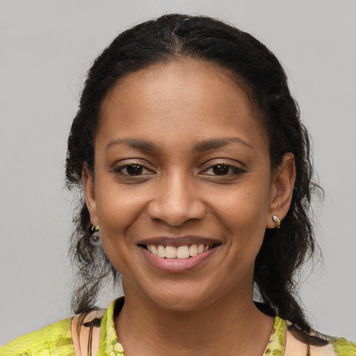 Joyful black young-adult female with medium  brown hair and brown eyes