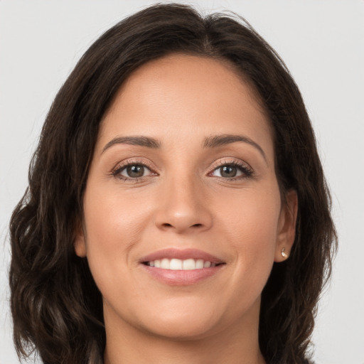 Joyful white young-adult female with long  brown hair and brown eyes