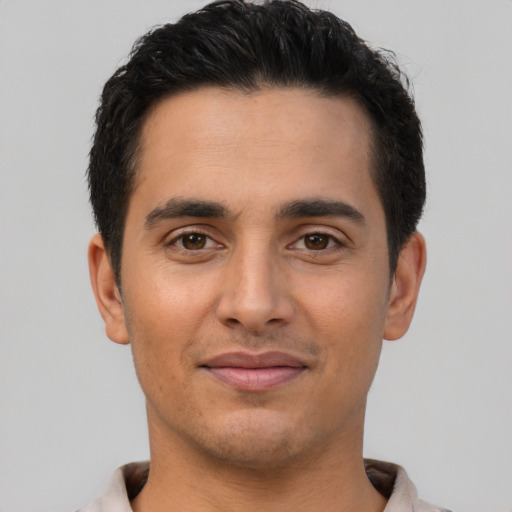 Joyful latino young-adult male with short  black hair and brown eyes
