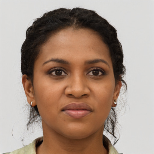 Joyful black young-adult female with long  brown hair and brown eyes